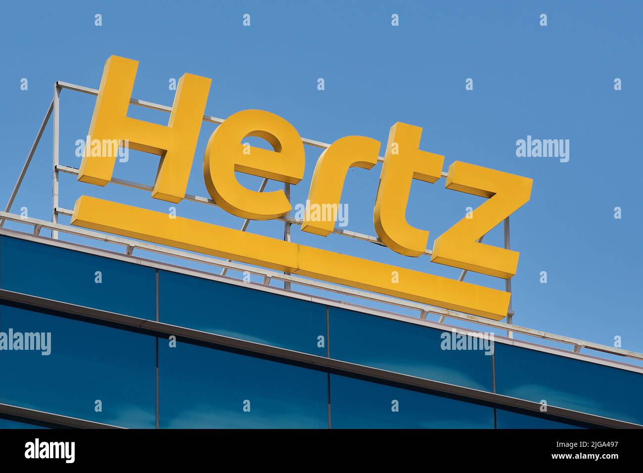 Bucharest, Romania - July 05, 2022: The logo of the American car rental company Hertz can be seen on a building. This image is for editorial use only. Stock Photo