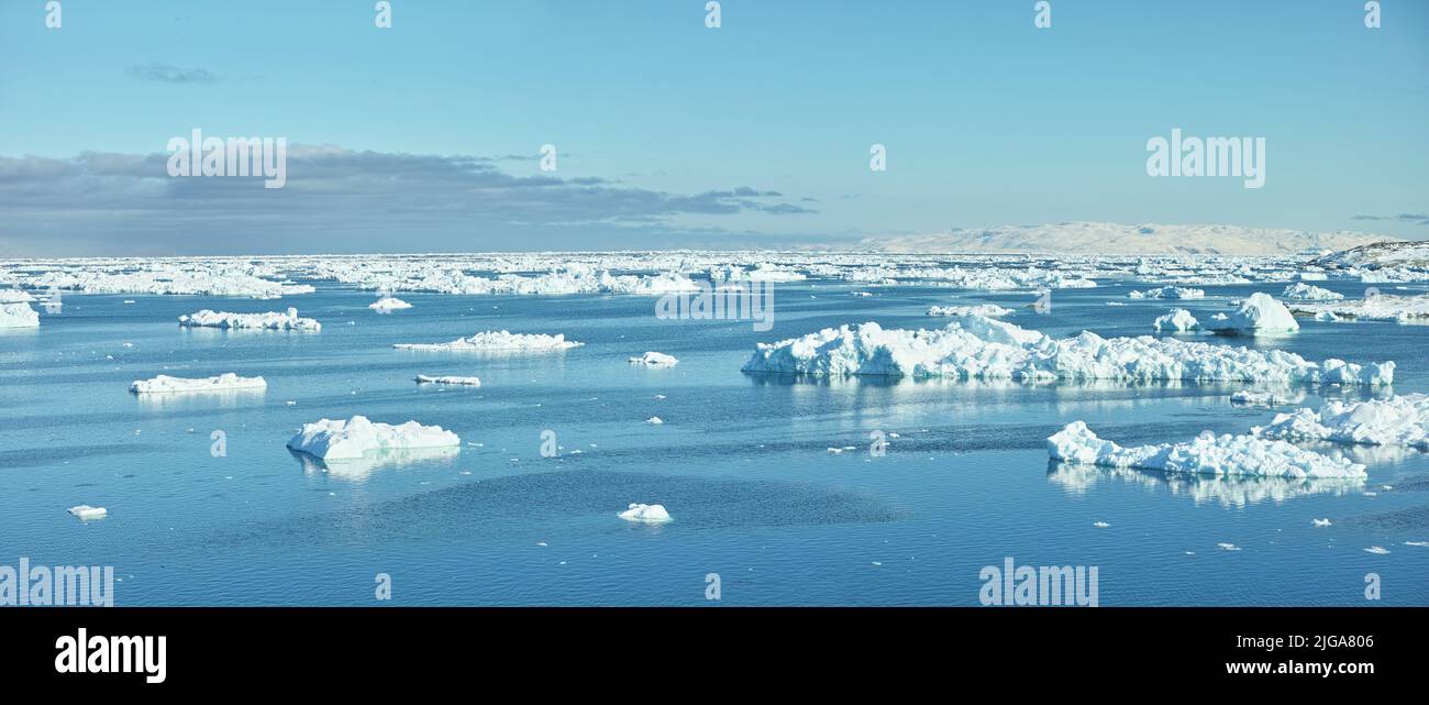 Beautiful landscape of the sea with ice on a cold winter day with a blue sky with copy space. Small iceberg in the ocean outdoors in nature in the Stock Photo