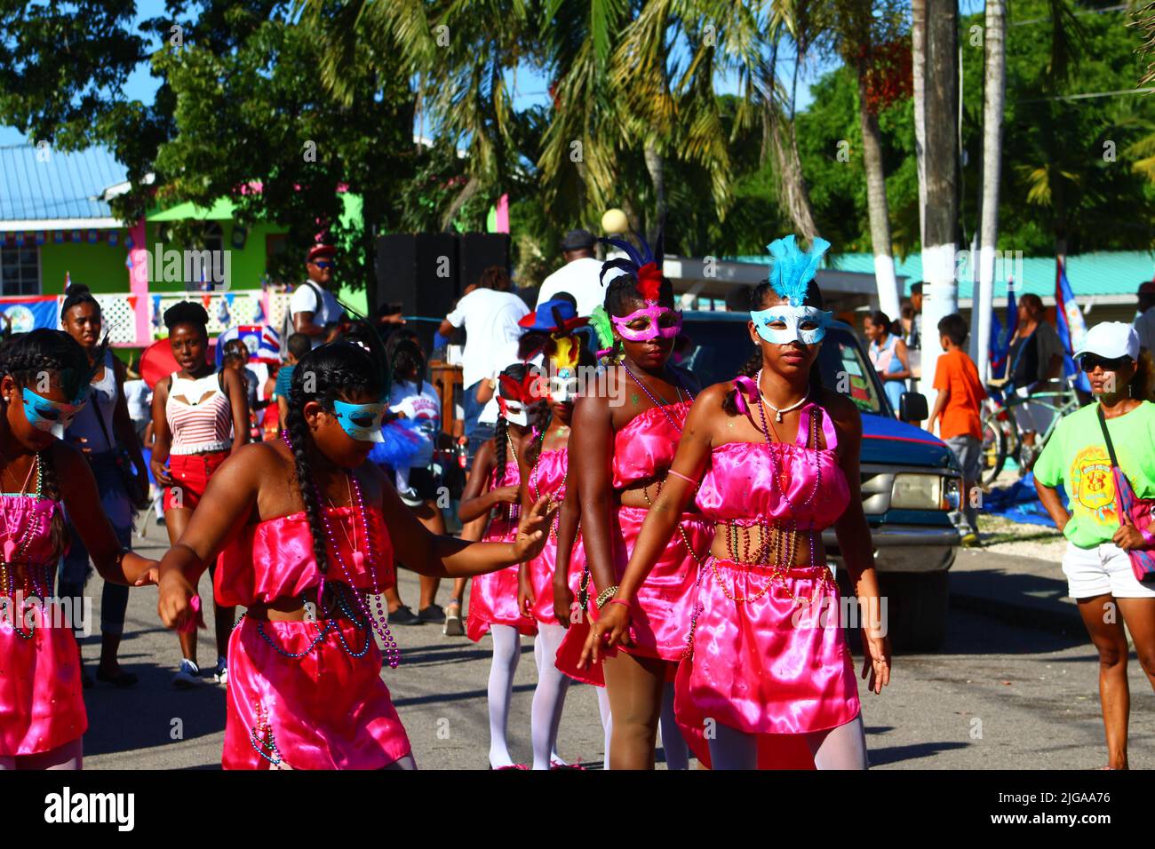 PUNTA GORDA, BELIZE - SEPTEMBER 10, 2016 St. George’s Caye Day celebrations and carnival lines of girls in pink costumes with masks with onlookers Stock Photo
