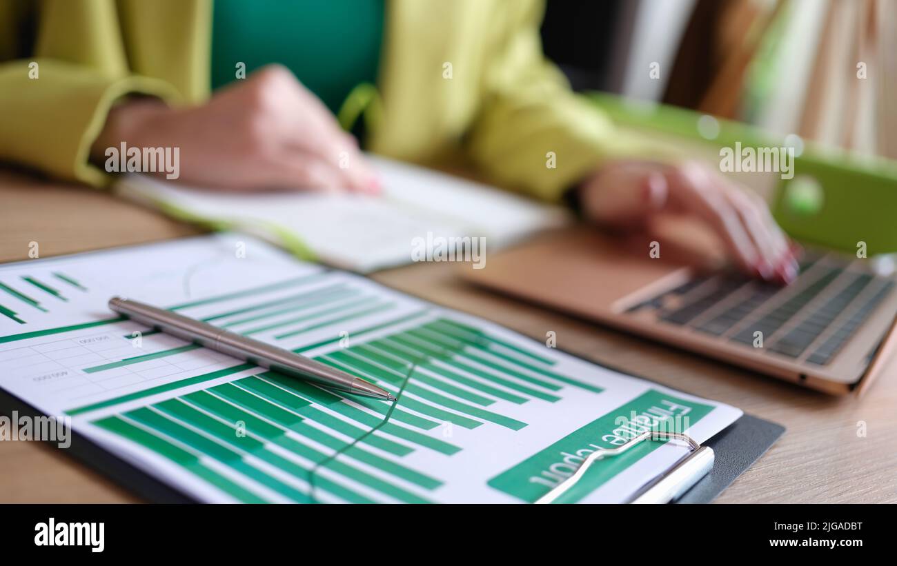 Accountant working with financial report and typing on modern laptop ...