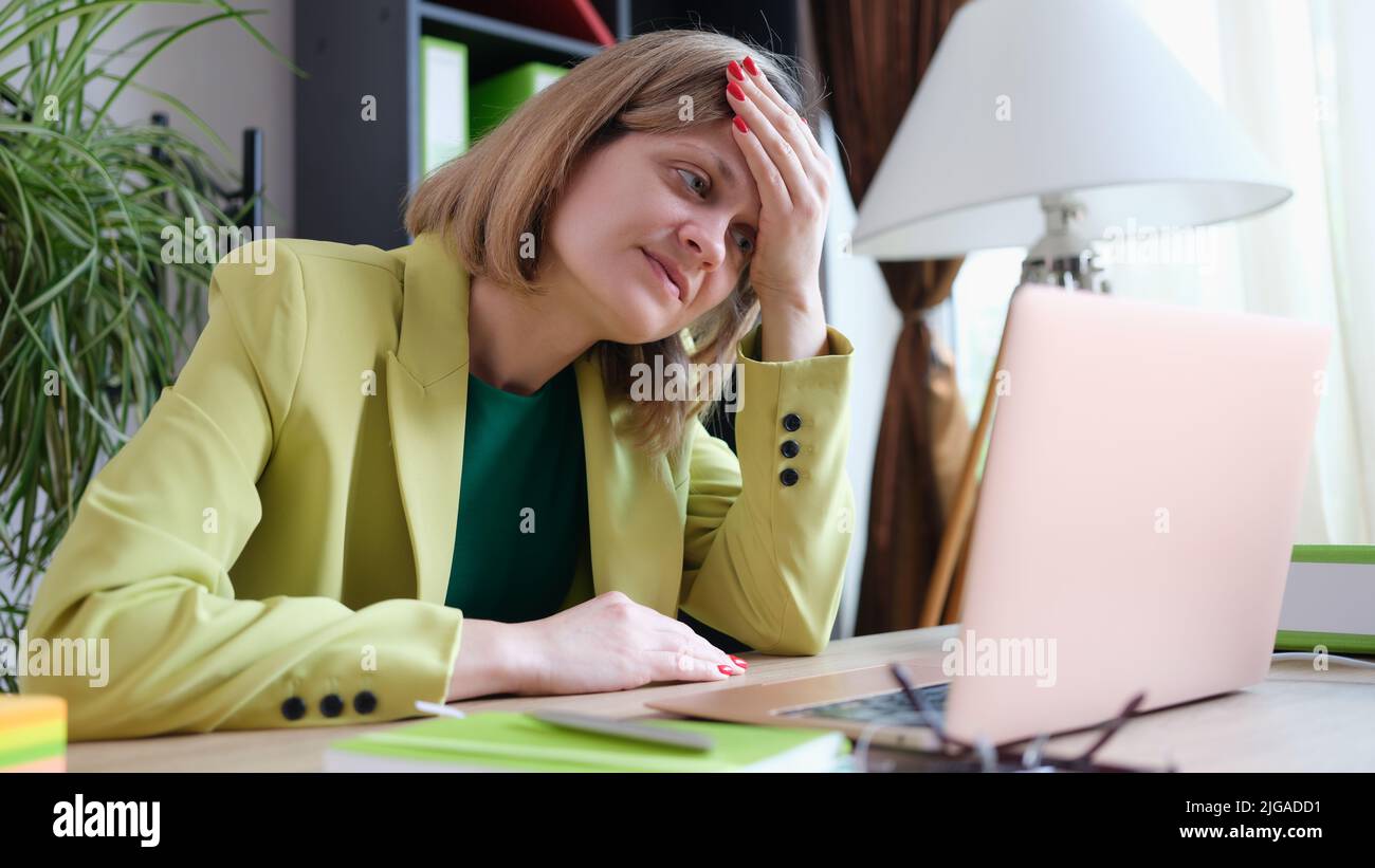 Tired woman working using modern laptop in office Stock Photo
