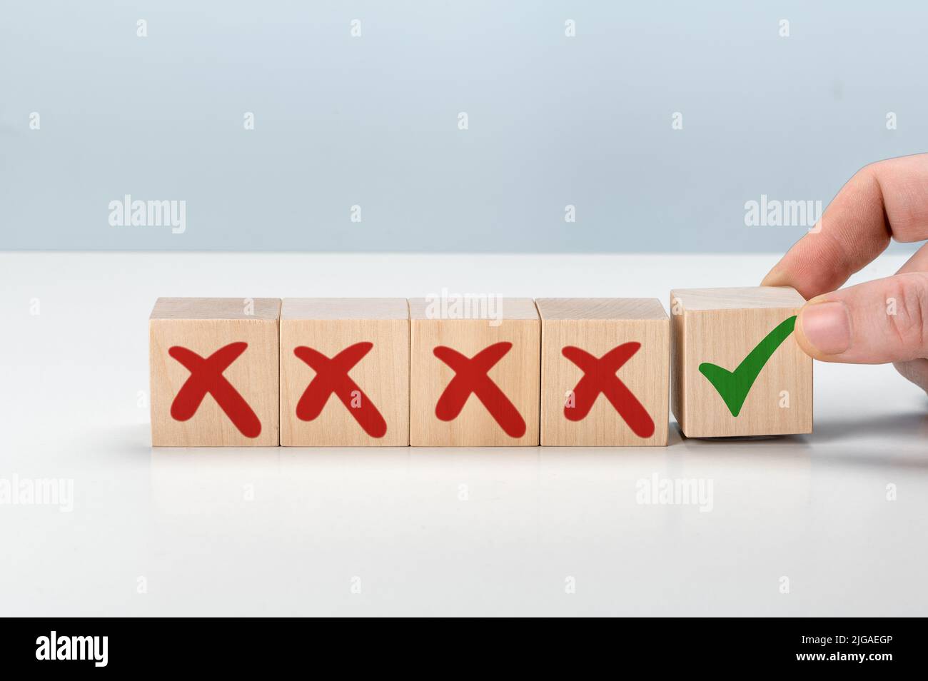 Man Hand selects checkbox with green checkmark from row of multiple boxes with red crosses. Pro and contra or Accept and Decline. Strategy of choice. Stock Photo