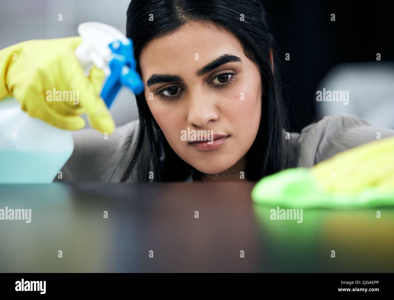 We dont want any dirt left. a young woman cleaning a surface at home