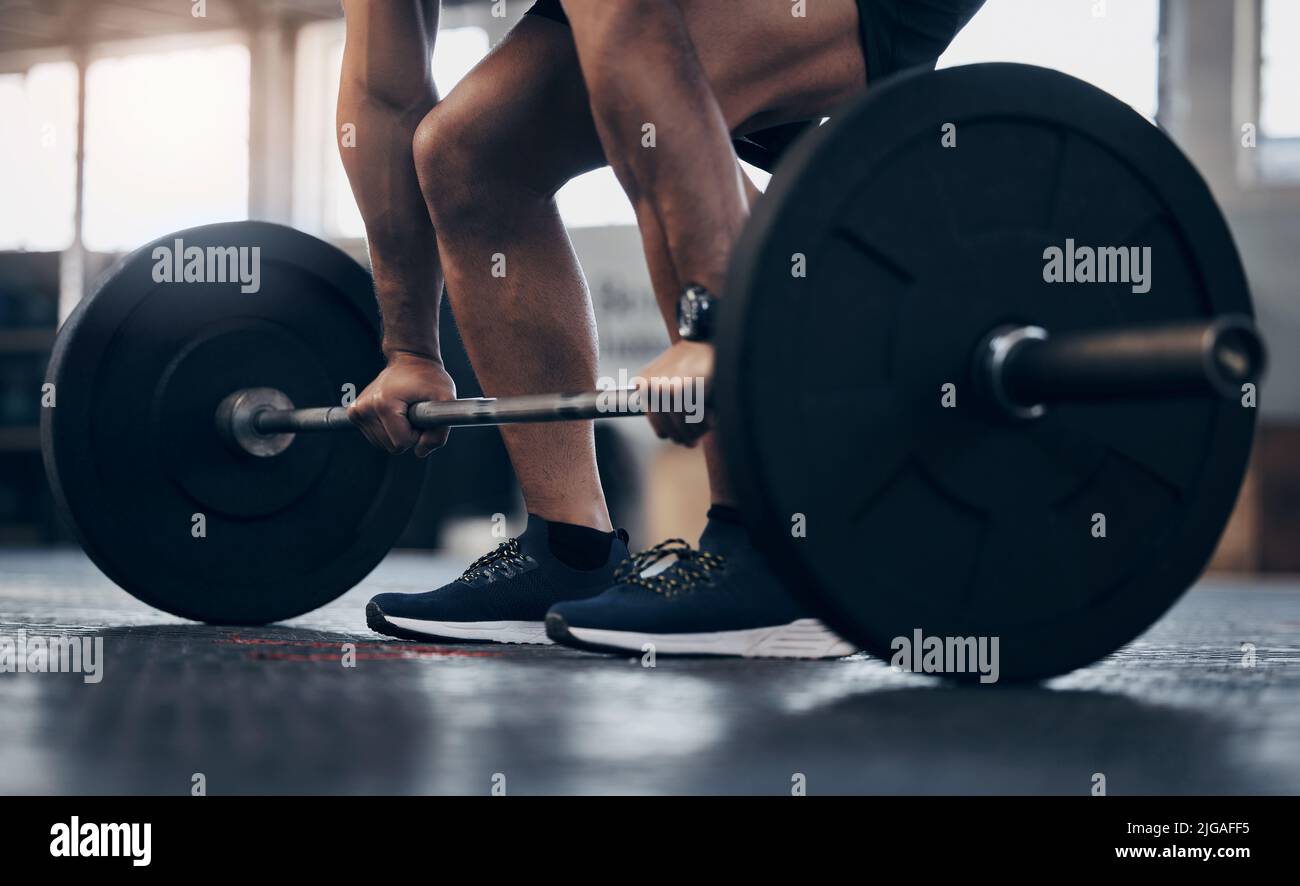 Its simple - do the work if you want the results. Closeup shot of an unrecognisable man exercising with a barbell in a gym. Stock Photo