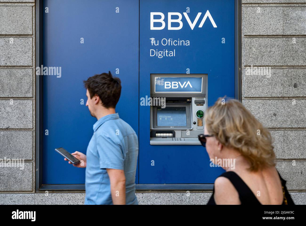 Madrid, Spain. 08th July, 2022. Pedestrians walk past an ATM machine at the Spanish multinational Banco Bilbao Vizcaya Argentaria SA (BBVA) bank branch in Spain. (Photo by Xavi Lopez/SOPA Images/Sipa USA) Credit: Sipa USA/Alamy Live News Stock Photo
