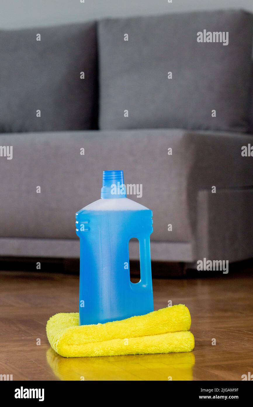 Floor cleaner in a plastic bottle and a floor cloth on the parquet
