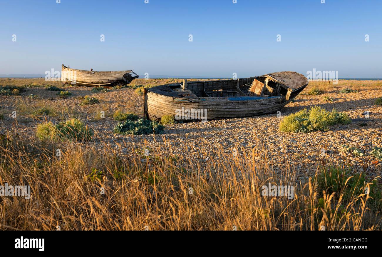 Old wrecked fishing boats on the shingle of Dungeness beach on the Kent coast south east England Stock Photo