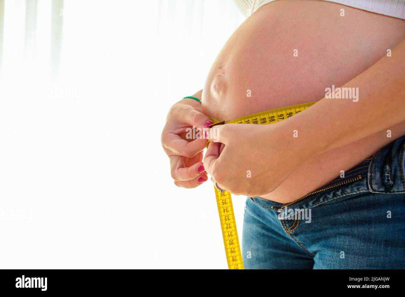 pregnant woman measuring her belly Stock Photo