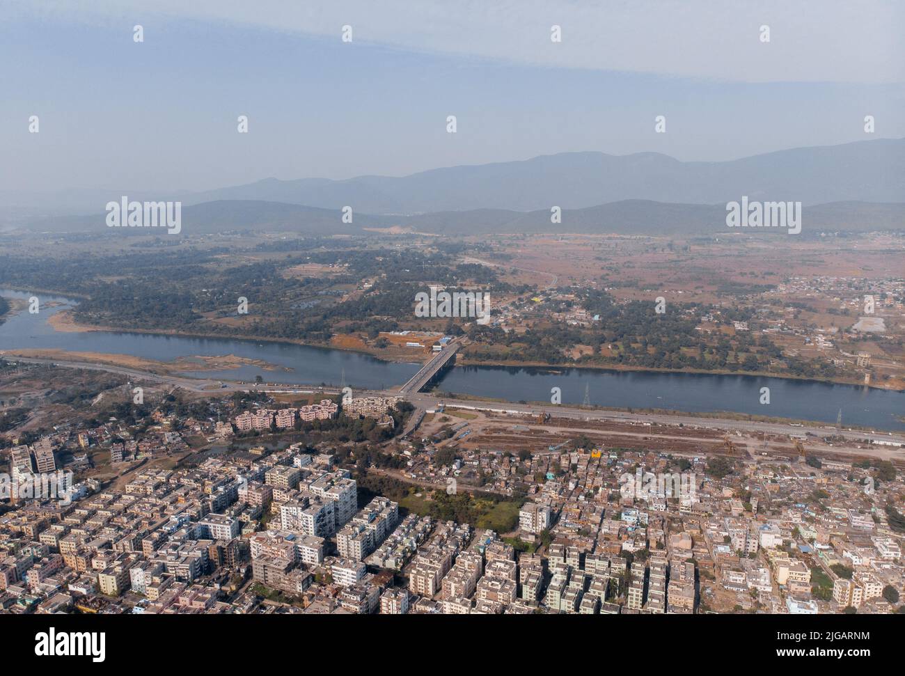 A bird's eye view of Jamshedpur city near a river against mountains in