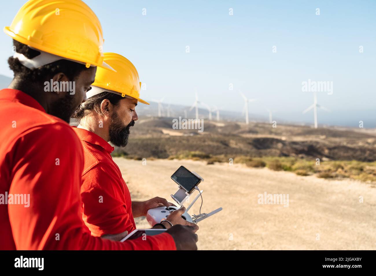 Drone engineers working on wind turbine farm - Alternative energy and aerial engineering concept Stock Photo