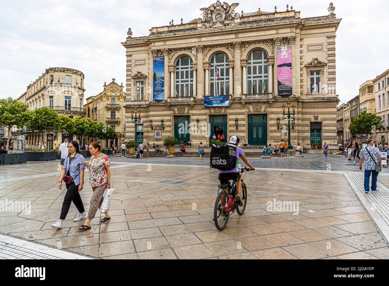 Pedestrian zone with cyclists in front of the opera house (Comedie) of Montpellier, France Stock Photo