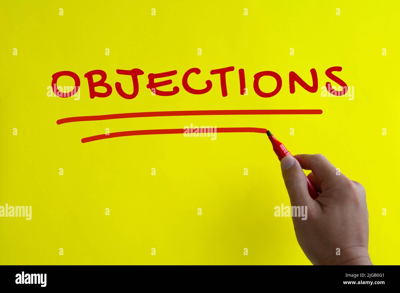 Hand writing objections text on yellow background. Objections concept Stock Photo