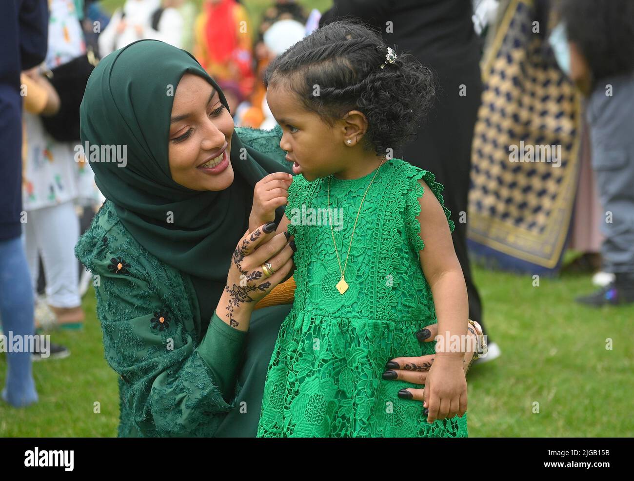 A child talks to her mother during the Eid festival at Davitt Park GAA grounds in Belfast. The Eid festival is an important day in the the Muslim celendar when food is shared with relatives, friends and the poor. Picture date: Saturday July 9, 2022. Stock Photo