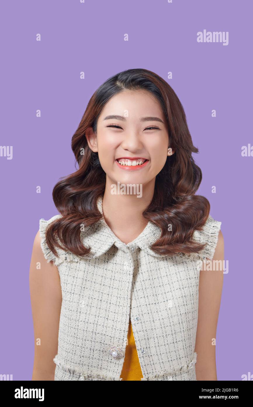 Beautiful young asian colorful stand and pose with big smile happy beaming face on purple ackground Stock Photo