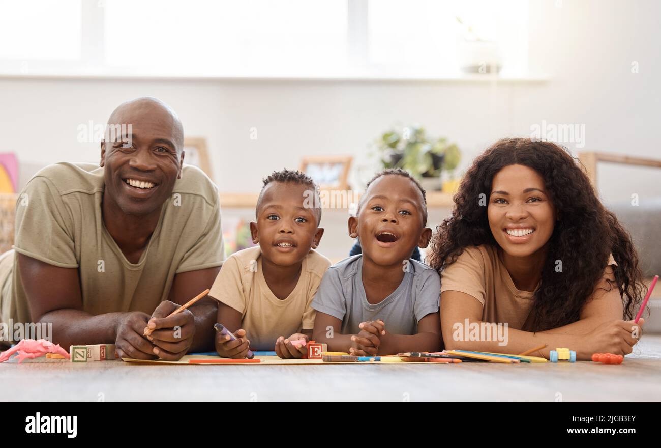 With lots of fun comes lots of smiles. a happy young family playing together on the floor at home. Stock Photo