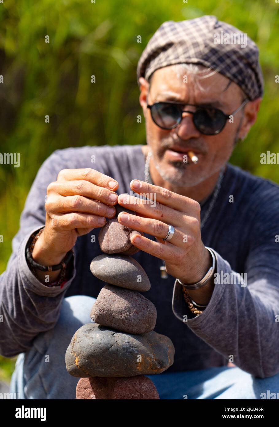 Dunbar, Scotland, UK. 9 July 2022. Day one of the 11th Stone Stacking Championships held at Eye Cave Beach in Dunbar in East Lothian. . Competitors are shown during the arch building competition. Pic; Charley Jordan builds a stone tower.  Iain Masterton/Alamy Live News Stock Photo