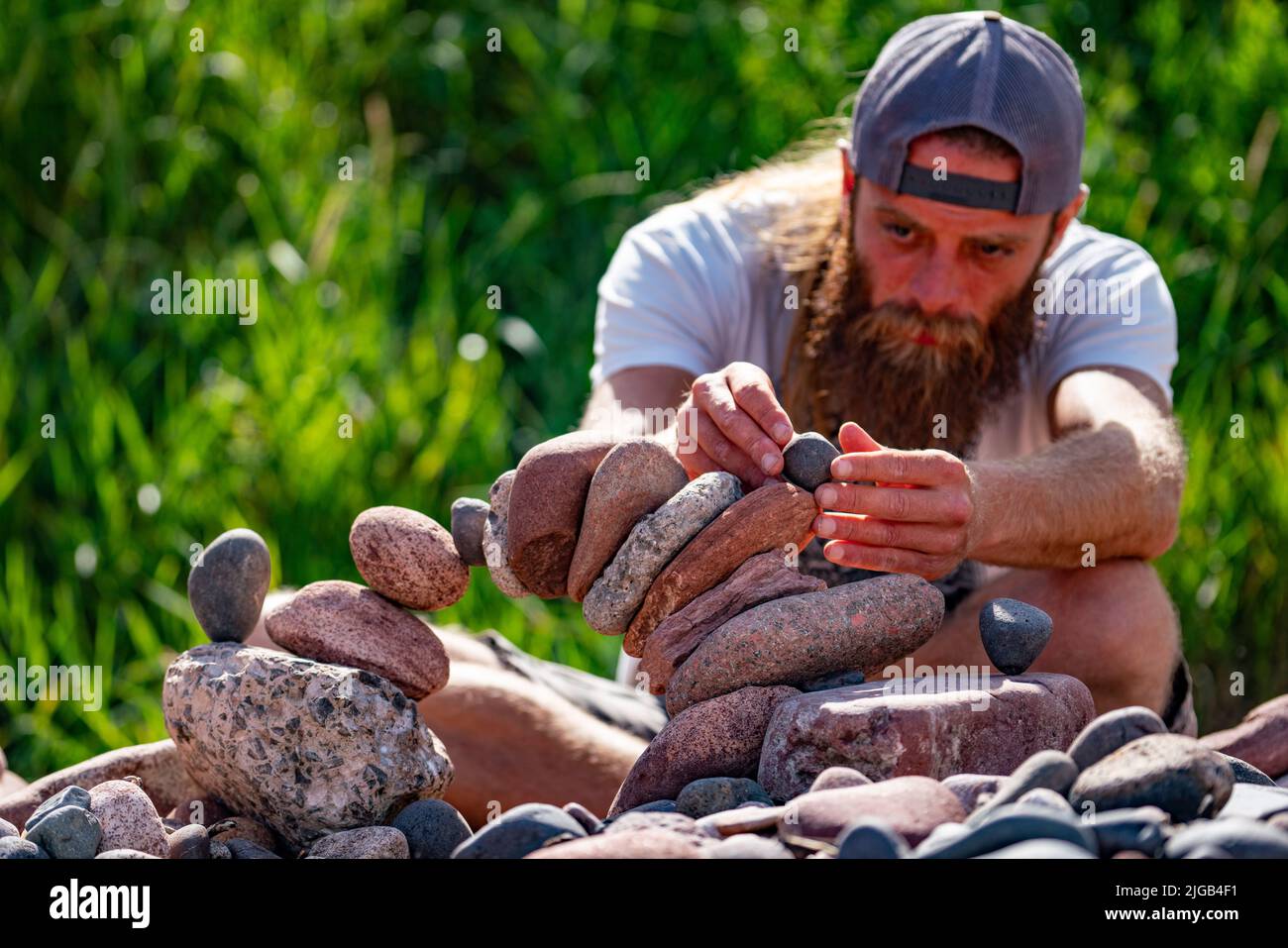 Dunbar, Scotland, UK. 9 July 2022. Day one of the 11th Stone Stacking Championships held at Eye Cave Beach in Dunbar in East Lothian. . Competitors are shown during the arch building competition. Pic; John Foreman concentrates on his stone arch. ain Masterton/Alamy Live News Stock Photo