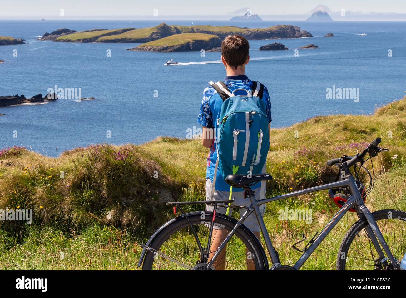 Valentia Island County Kerry, Ireland. 9th July 2022. Young cyclist viewing the Skellig Rocks from Valentia Island, County Kerry, Ireland Credit: Stephen Power/Alamy Live News Stock Photo