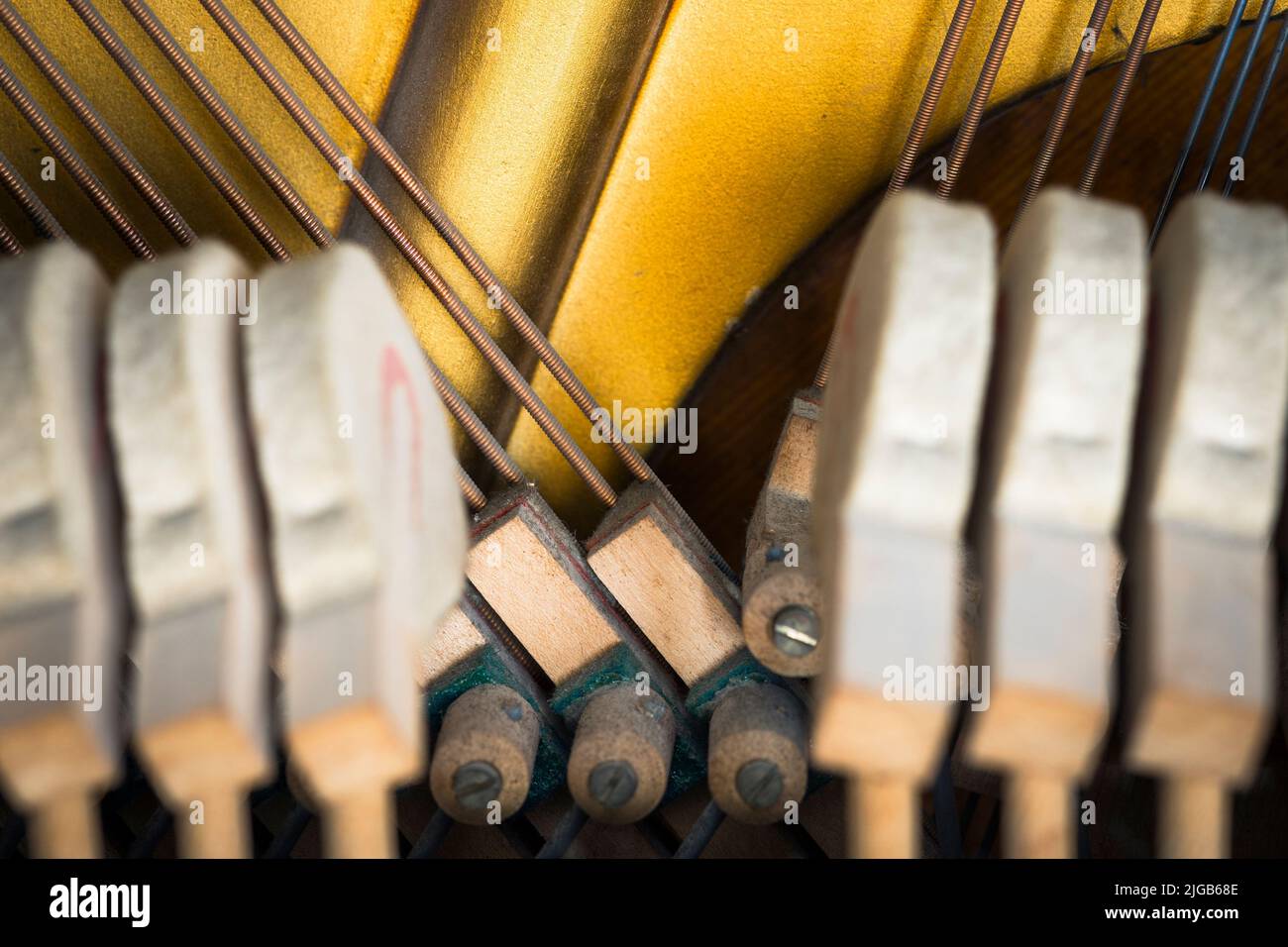 Dampers of an upright piano framed by hammers Stock Photo