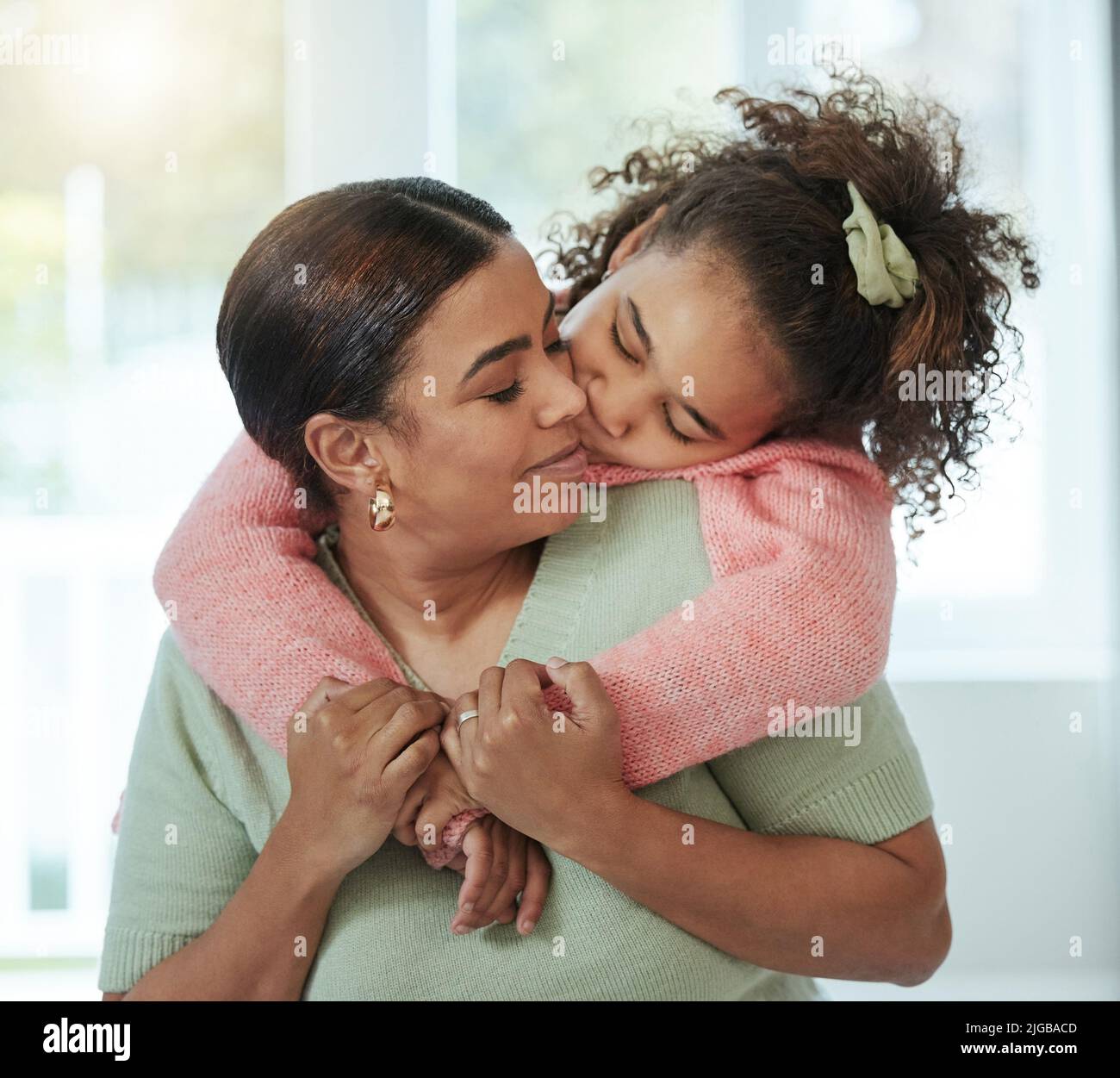 I love you so much, mom. an adorable little girl embracing her mother from behind Stock Photo