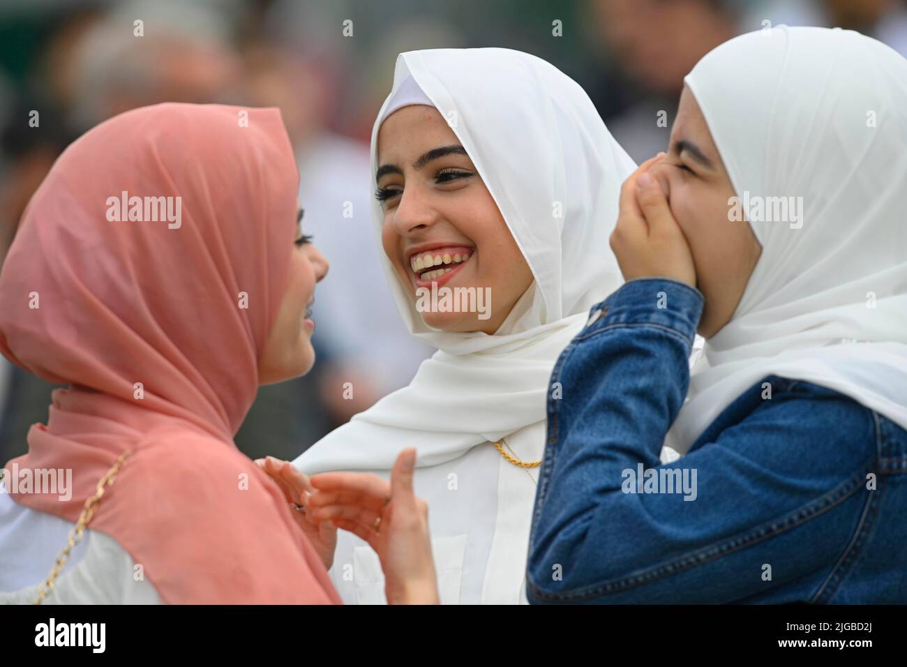 Young worshippers laugh during the Eid festival at Davitt Park GAA grounds in Belfast. The Eid festival is an important day in the the Muslim celendar when food is shared with relatives, friends and the poor. Picture date: Saturday July 9, 2022. Stock Photo
