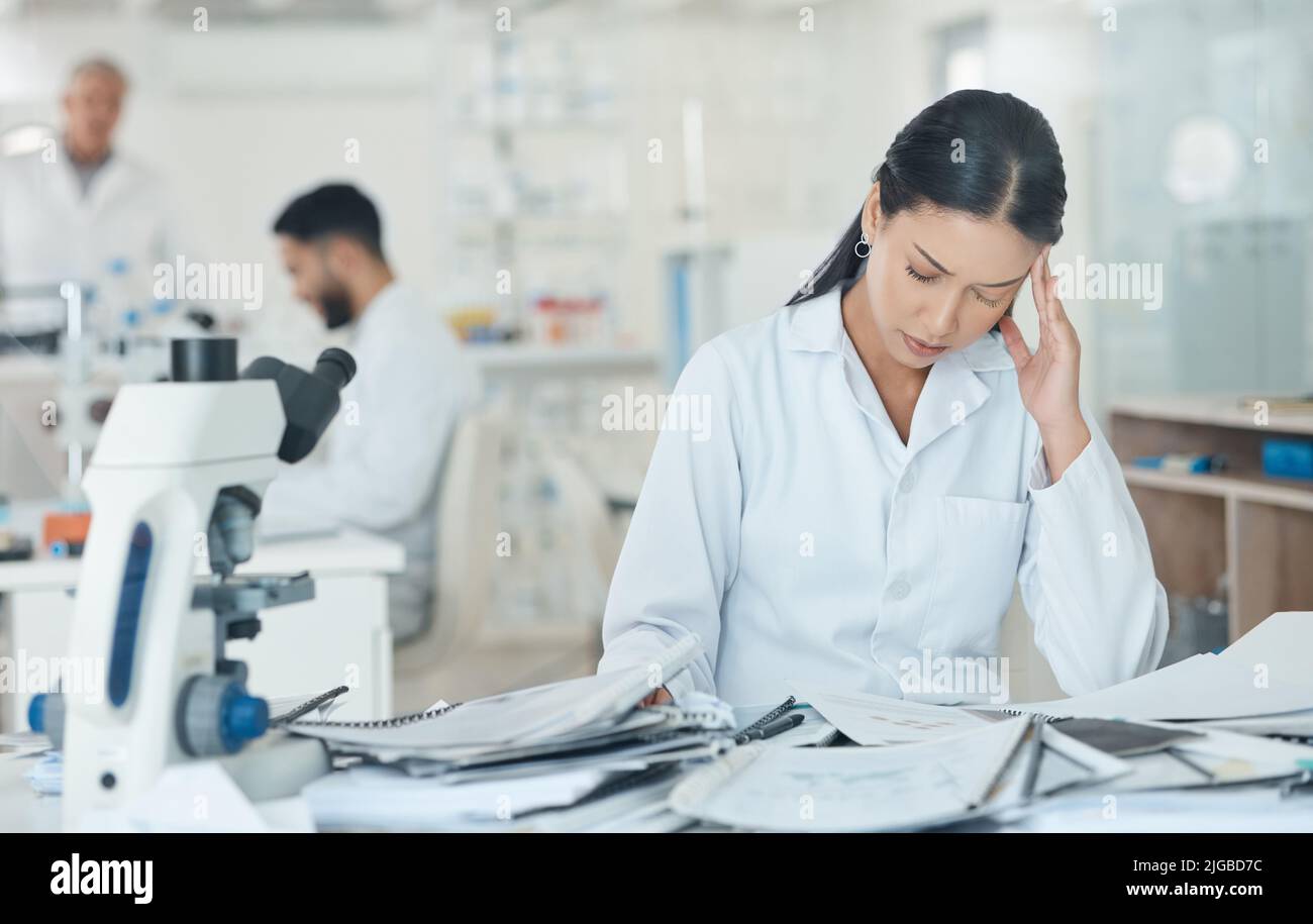Ive been at this for so long already. a young scientist looking stressed out while working in a lab. Stock Photo