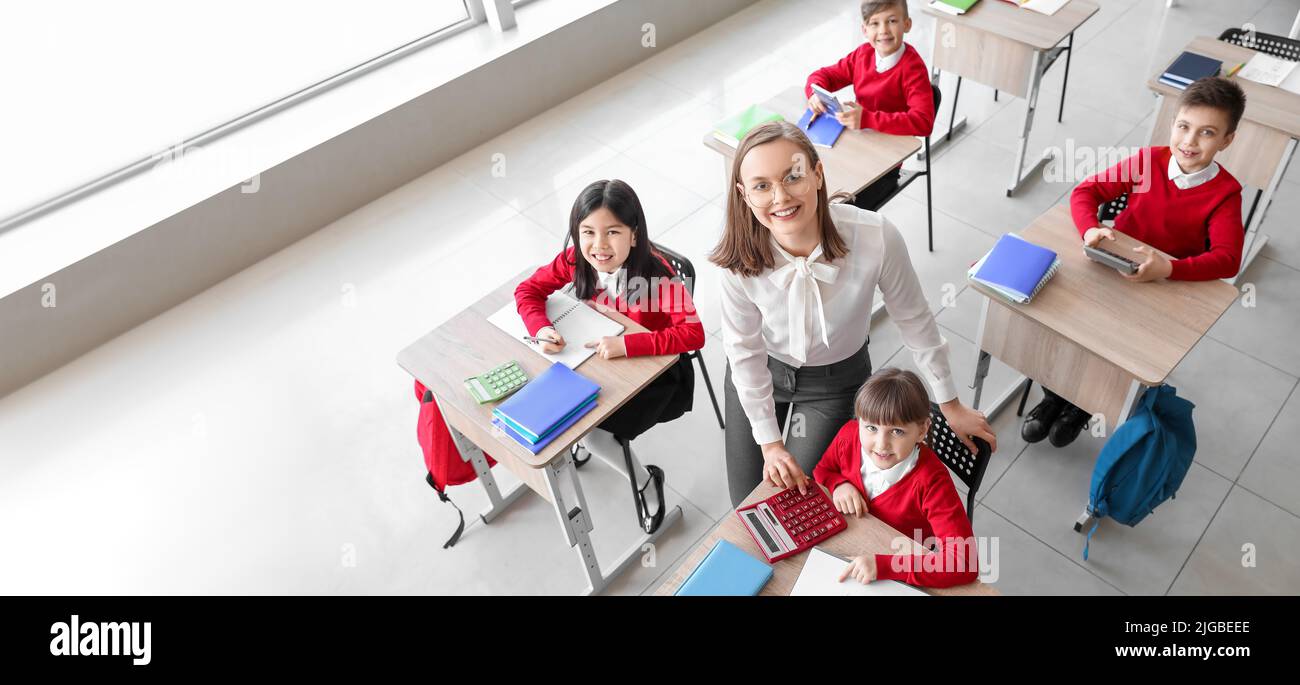 Children and maths teacher during lesson in classroom, top view Stock Photo