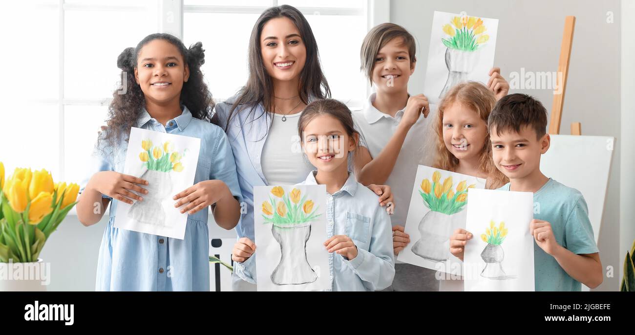 Drawing teacher and cute children with pictures at school Stock Photo ...