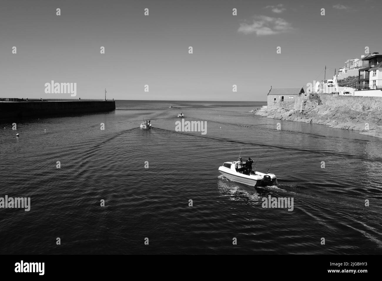 Boats leaving Porthleven Harbour, Cornwall Stock Photo