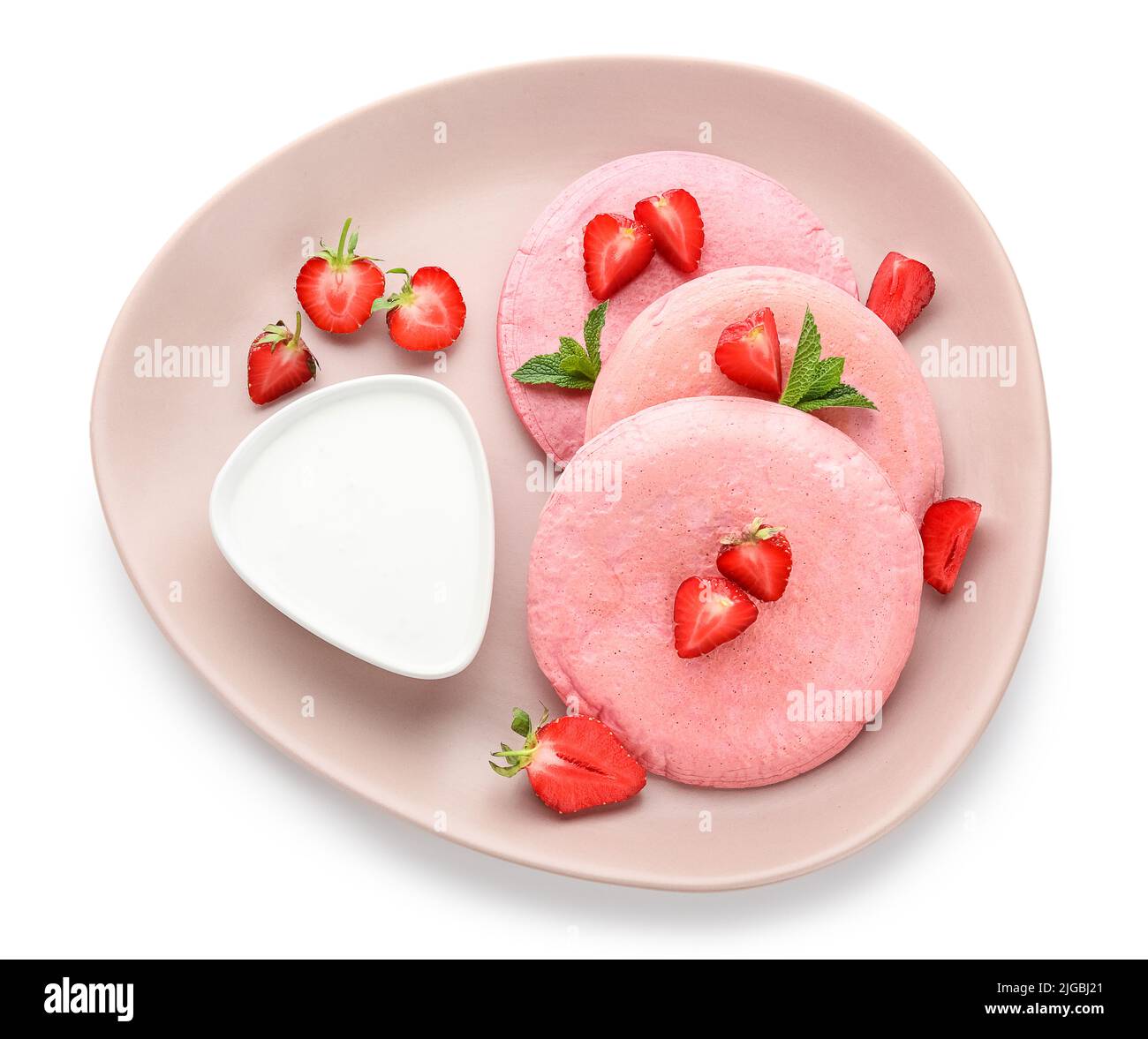 Plate with pink pancakes, strawberry and sour cream isolated on white