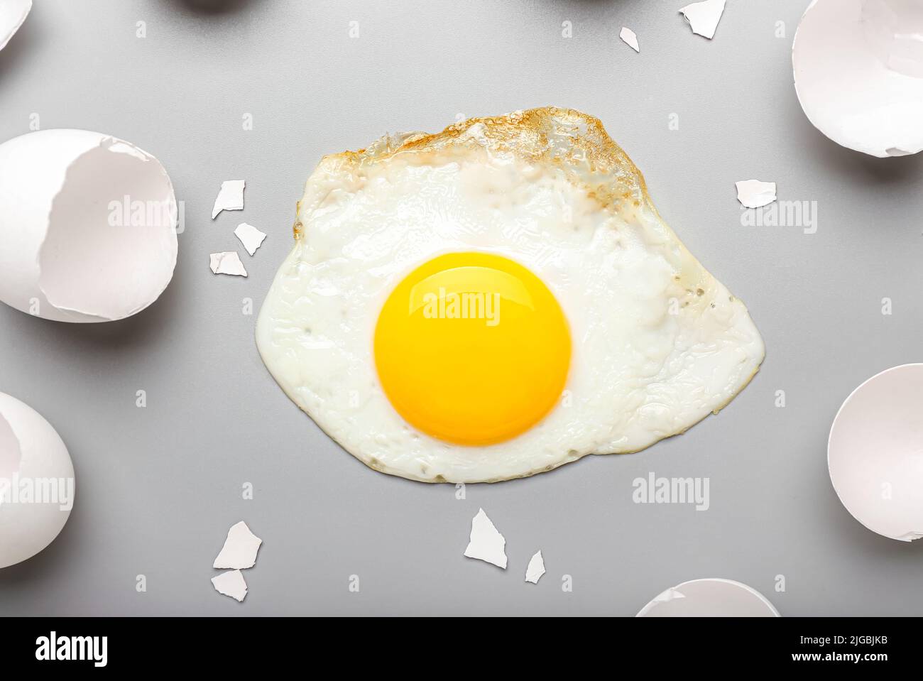 https://c8.alamy.com/comp/2JGBJKB/composition-with-tasty-fried-egg-and-shells-on-light-background-2JGBJKB.jpg