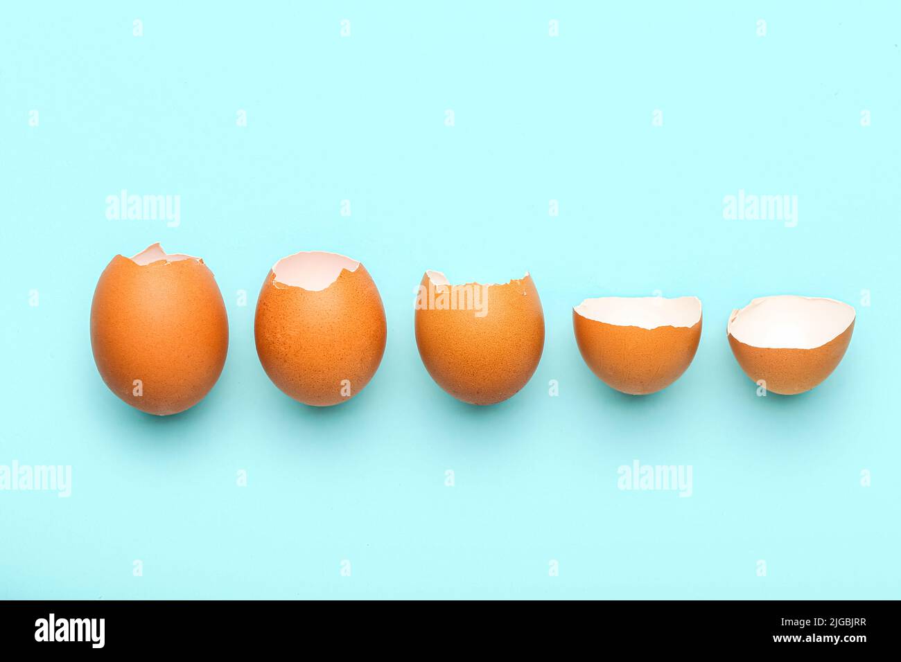 Composition with broken egg shells on blue background Stock Photo