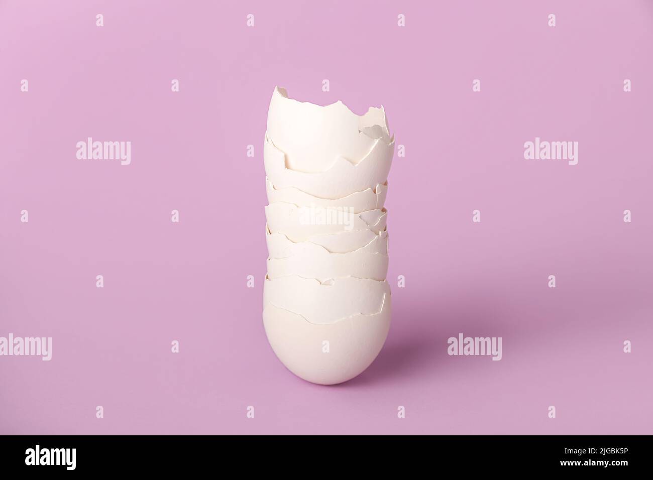 Stack of egg shells on lilac background Stock Photo