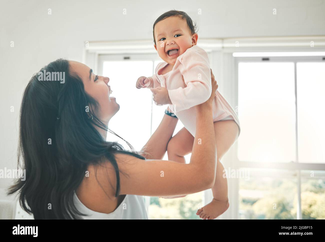 Such a happy baby. an attractive young woman and her newborn baby at home. Stock Photo
