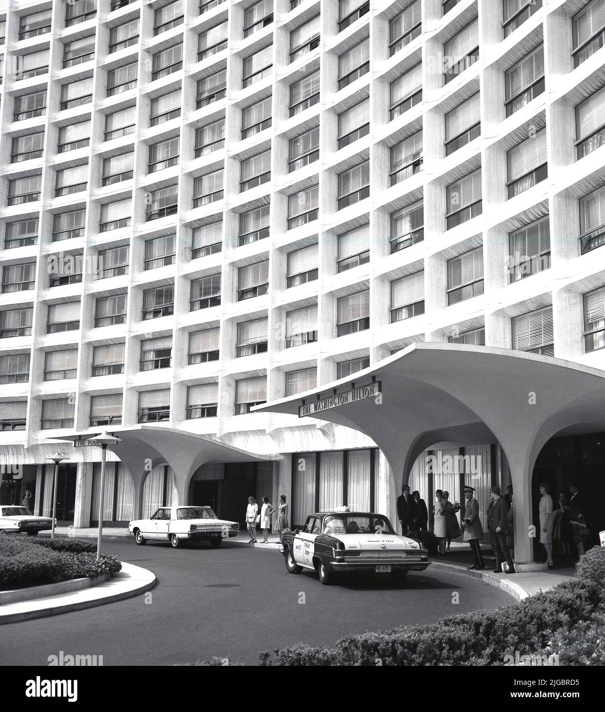 1960s, historical, exterior of The Washington Hilton, Washington, DC, USA, with a taxi of the Yellow Cab Company at the hotel entrance. The Four Oaks restaurant on the left. With over 1,000 bedrooms, the large hotel on Connecticut Avenue was designed by William B. Tabler and opened in 1965. Stock Photo