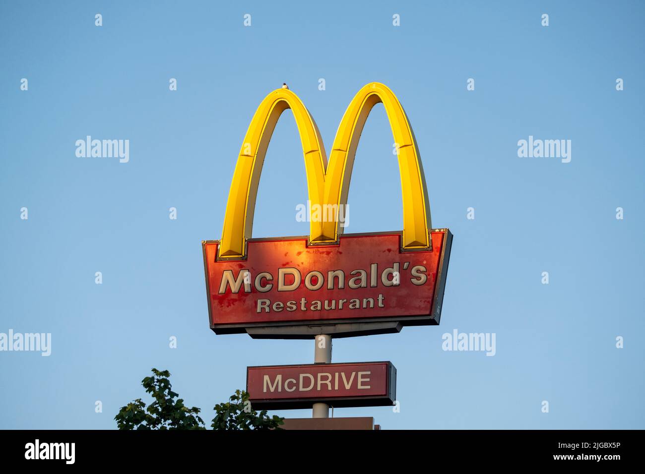 Helsinki / Finland - JULY 5, 2022: A tall Mc Donald's sign against a bright blue sky Stock Photo