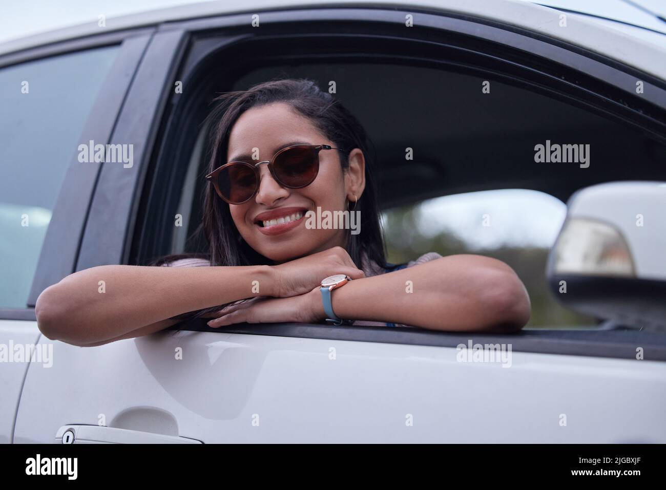 Im enjoying every minute of this road trip. a young woman leaning out a ...