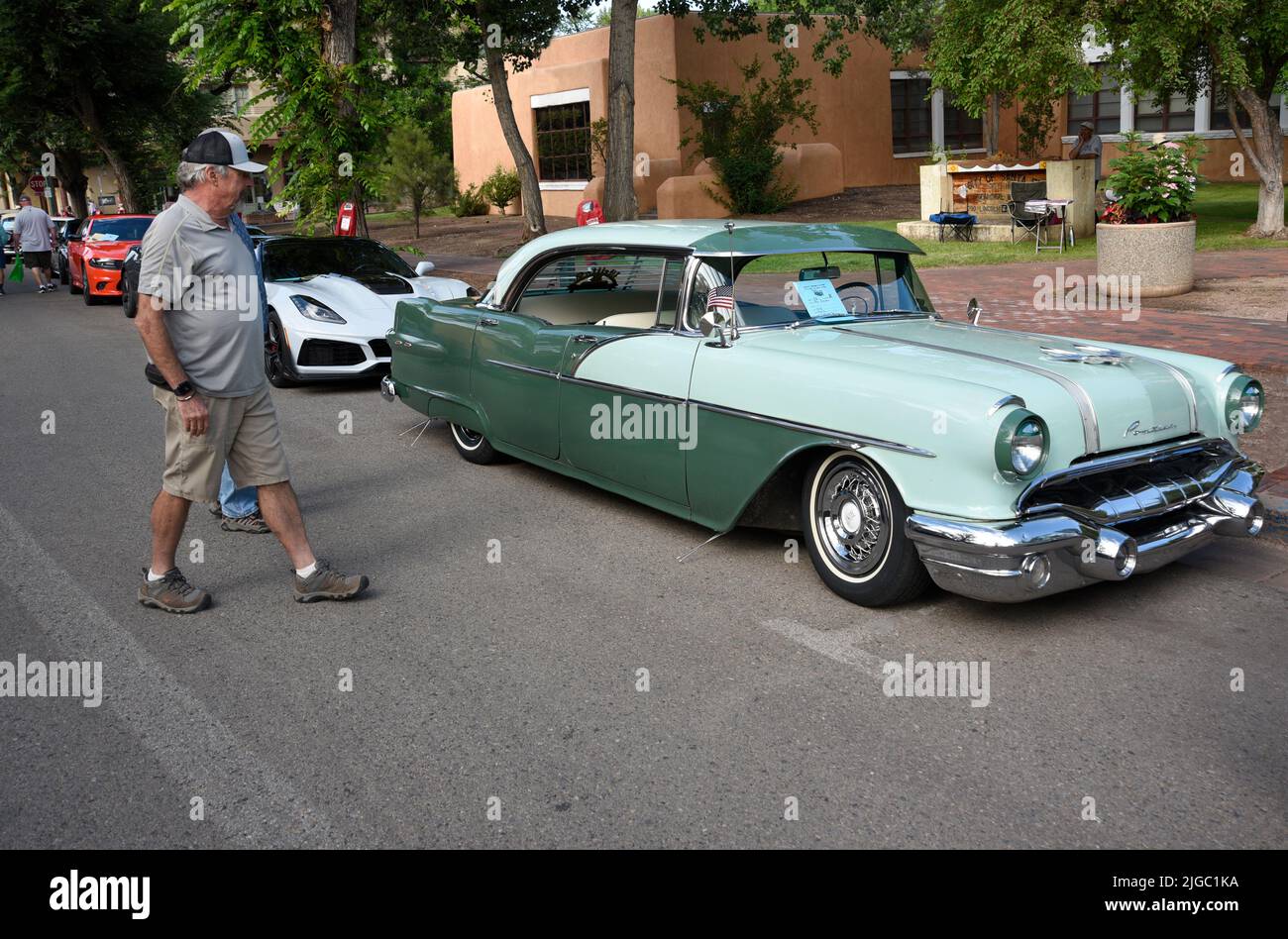 Car show visitors admire a 1956 Pontiac on display at a Fourth of July