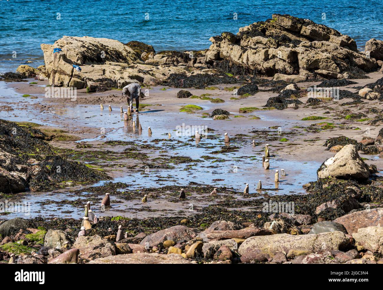 Dunbar, East Lothian, Scotland, UK, 9th July 2022. European Stone Stacking Championship: participants from all over the world have 3.5 hours to create an artistic artwork from the rocks on Eye Cave Beach. Credit: Sally Anderson/Alamy Live News Stock Photo