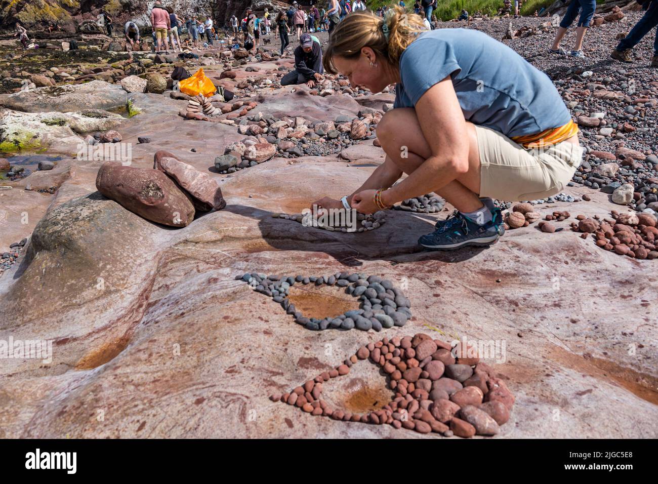 Dunbar, East Lothian, Scotland, UK, 9th July 2022. European Stone Stacking Championship: participants have 3.5 hours to create an artistic artwork from the rocks on Eye Cave Beach. Pictured: Marianne Winter from the Netherlands, who won this competition in 2019 Stock Photo