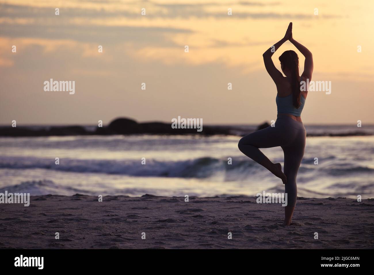 Be mindful of your movements. a unrecognizable female doing yoga at the beach. Stock Photo