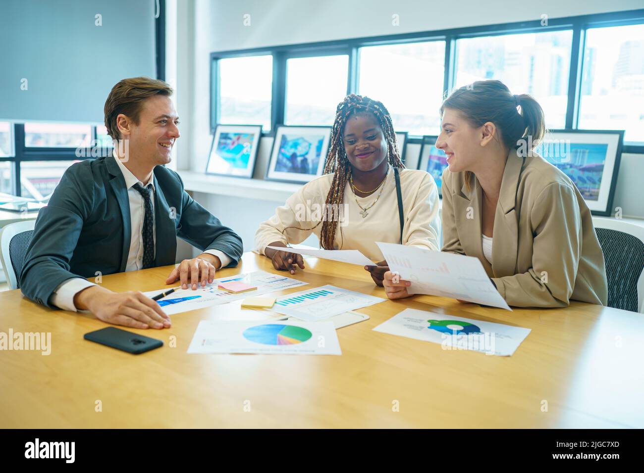 Image of young business people discussing document in paperwork data on ...