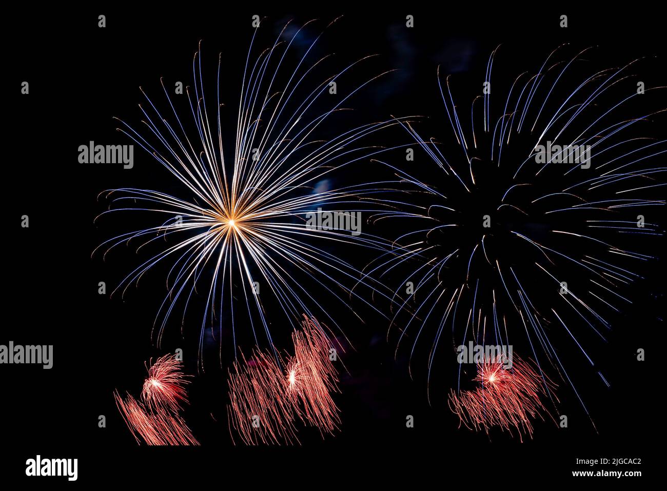 Montreal, Canada - June 25 2022: Fire works show with quarter moon in background at La Ronde in Montreal Stock Photo