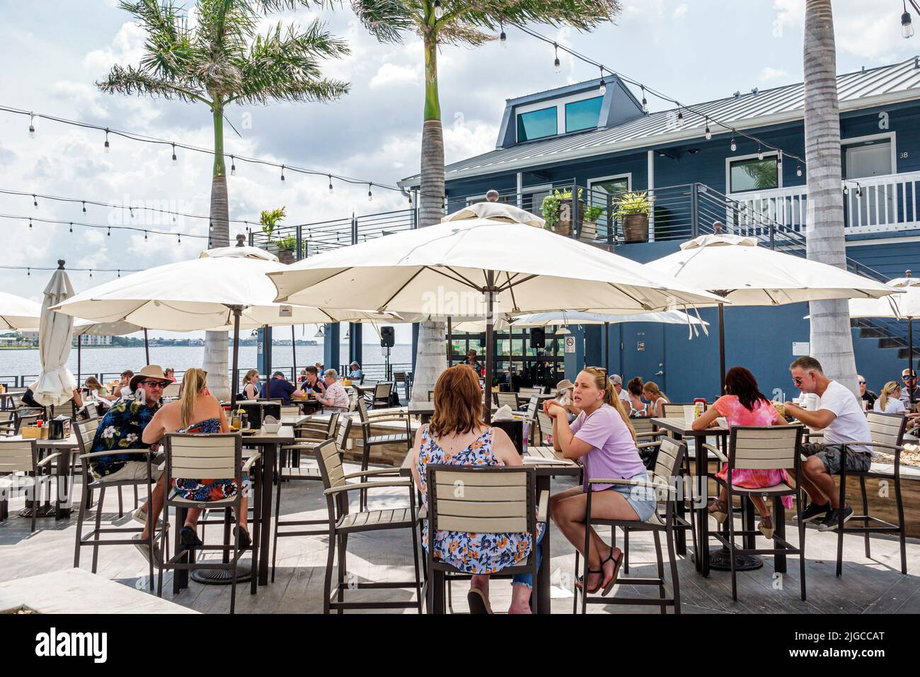 Punta Gorda Florida,Charlotte Harbor,Fishermen's Village shopping dining complex,Village Brewhouse restaurant restaurants al fresco dining tables umbr Stock Photo