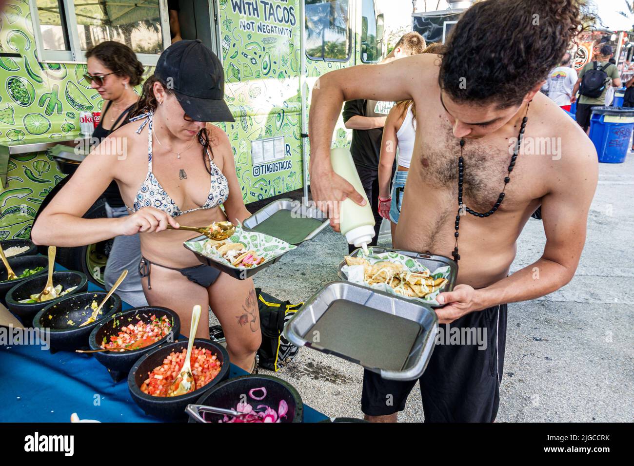 Miami Beach Florida,Ocean Terrace Fire on the Fourth 4th of July Festival event celebration,tacos food truck customers couple man woman adding sauce s Stock Photo