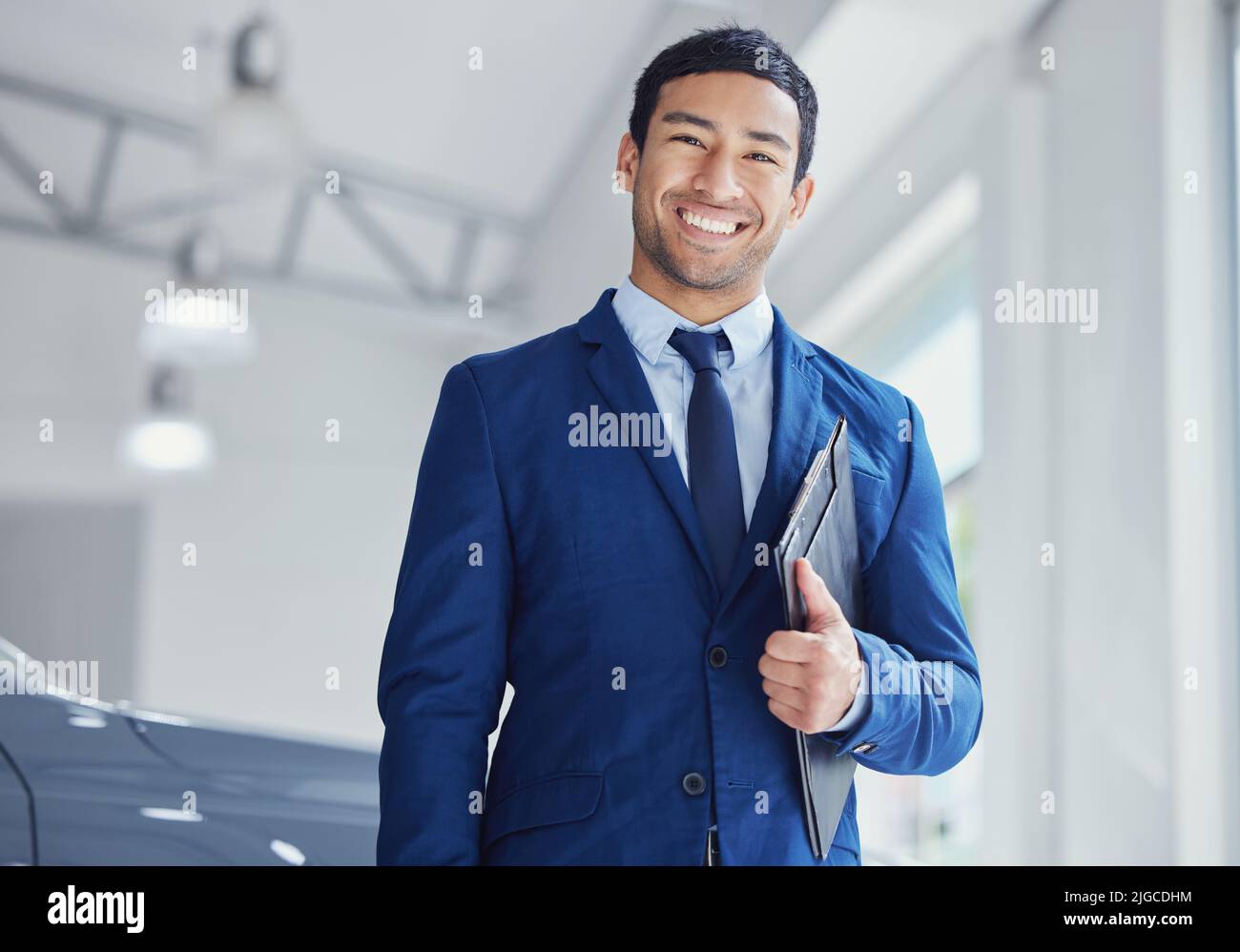 Ill get you your dream car. Cropped portrait of a handsome young male car salesman working on