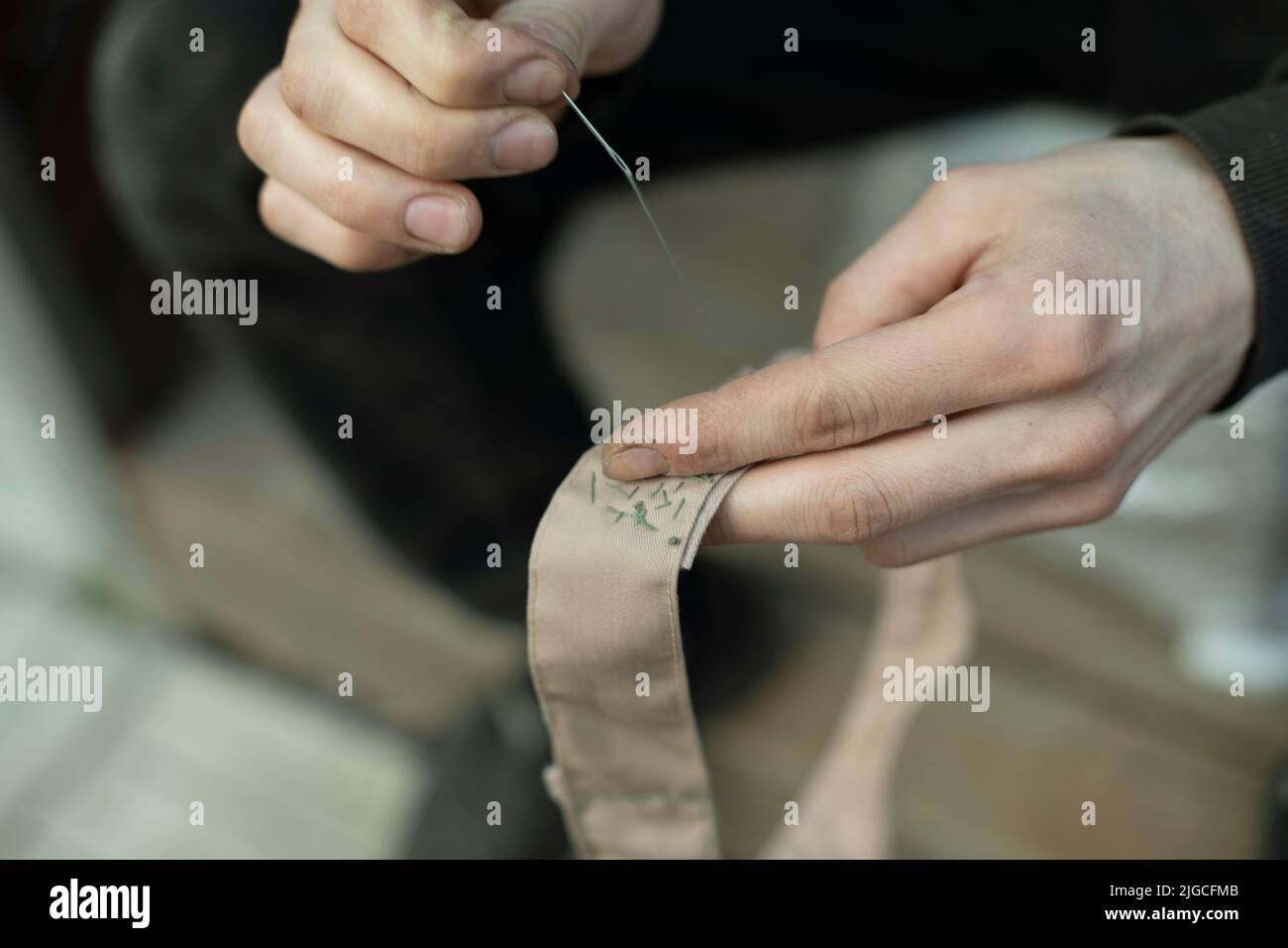 Sewing tape. Collar stitching in army. Work of weaver. Repair clothes with your own hands. Stock Photo
