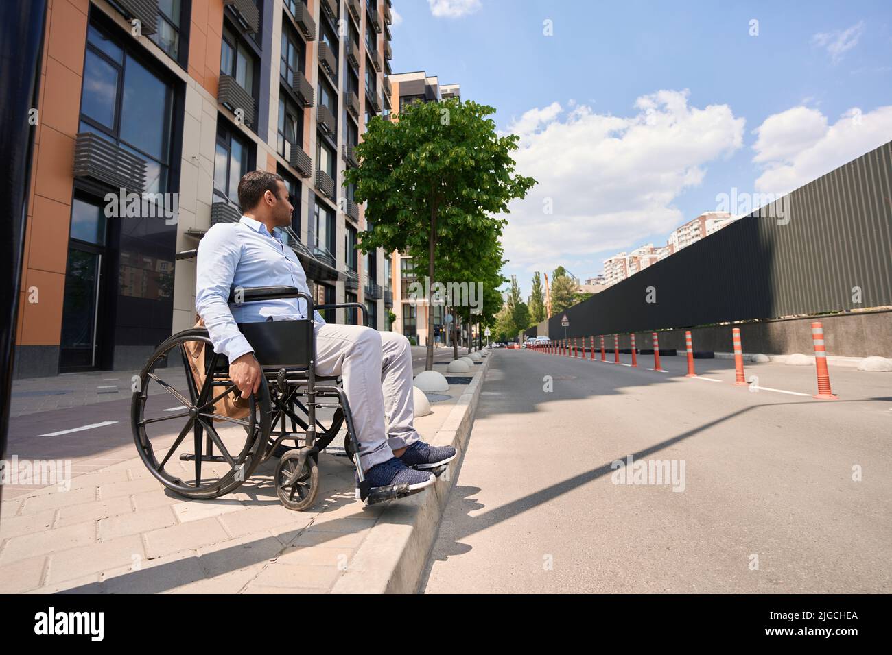 Man with disability trying to cross road Stock Photo