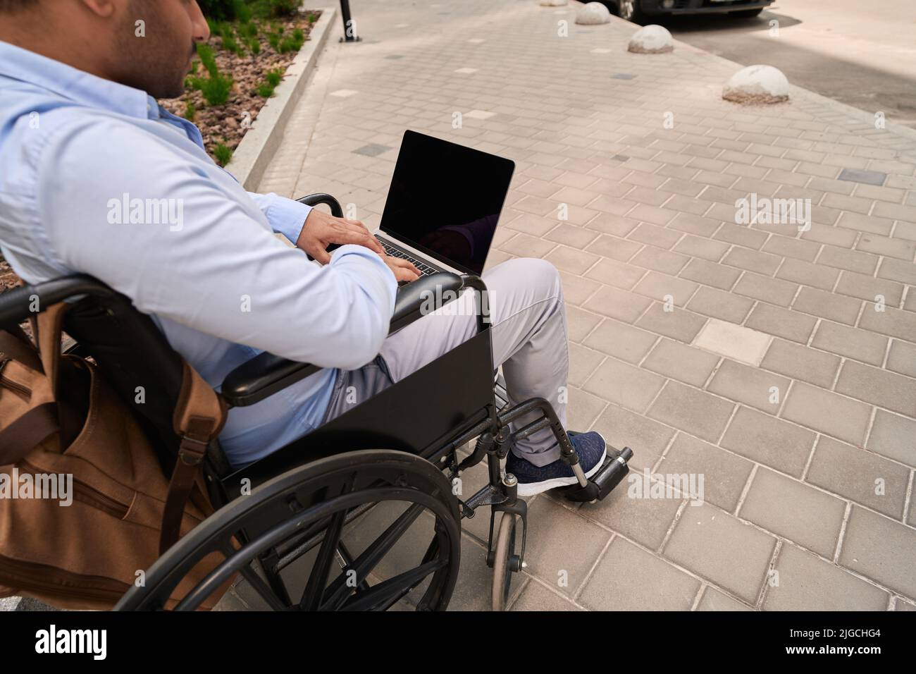 Man with disability using portable computer outdoors Stock Photo