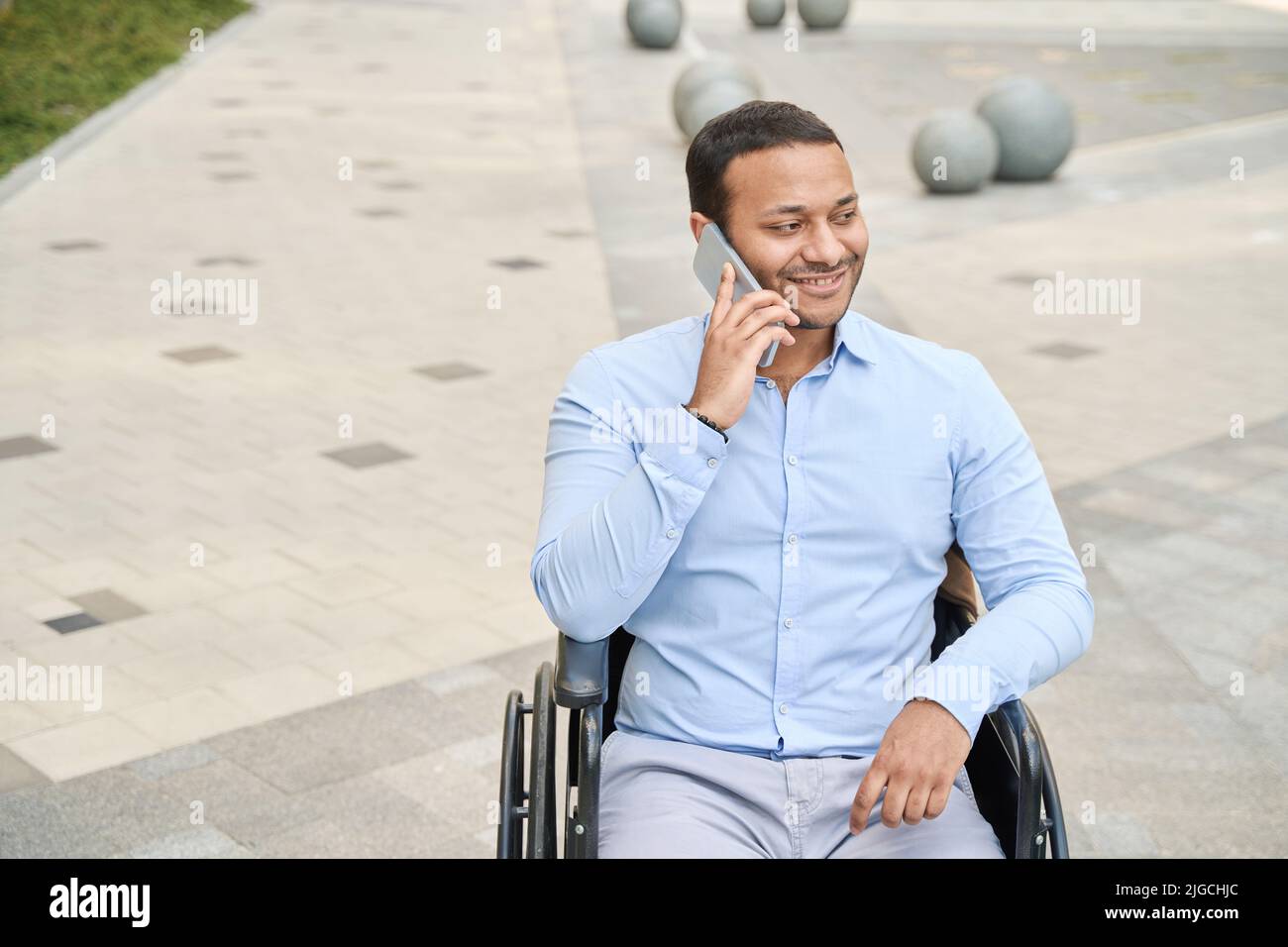 Man with disability smiling during phone call Stock Photo